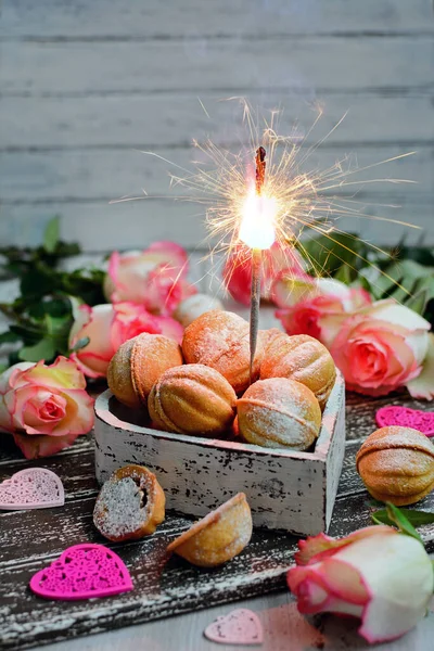 Composition verticale pour la Saint Valentin. Biscuits en forme de noix dans une boîte et scintillements sur un fond de fête. — Photo
