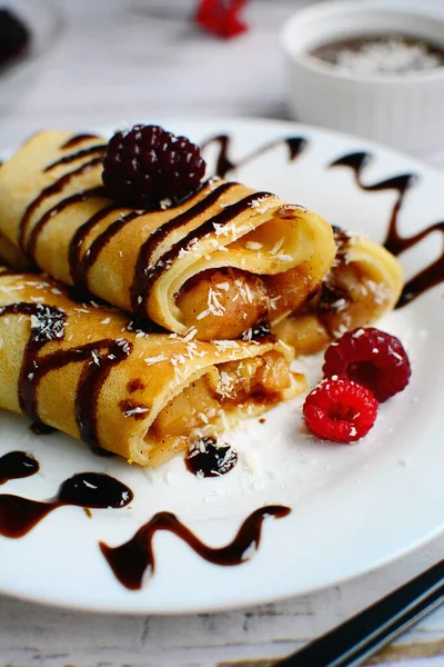 Closeup of pancakes with berry filling and caramel syrup on a white plate on a light background. Vertical — Stock Photo, Image