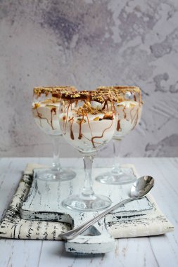 Gri beton arka planda çikolata parçalı süzme peynir sütlü mus. Dikey, yakın plan.