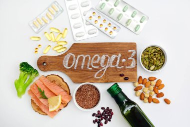 Doğru beslenme ve ilaç arasında seçim yapma kavramı. Omega-3 ve beyaz zemin üzerinde omega-3 olan ürünlerin yerleşimi.