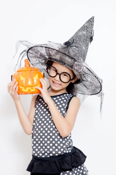 Happy heks kind met pompoen in halloween jurk — Stockfoto