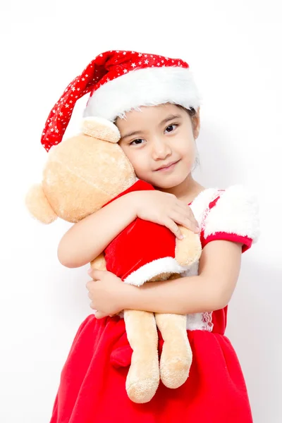 Pequena menina asiática abraçando urso boneca no Natal isolado em branco — Fotografia de Stock