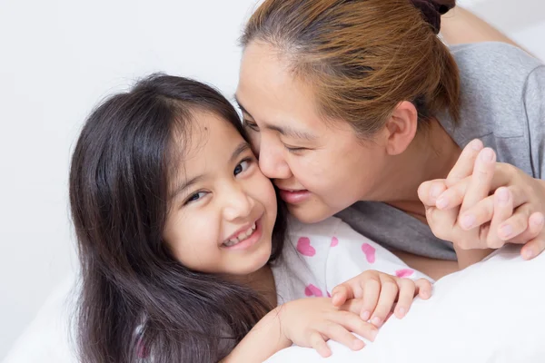 Porträt einer glücklichen asiatischen Mutter, die Tochter küsst — Stockfoto