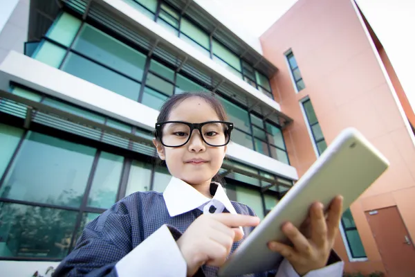 Деловой азиатский ребенок с планшетным фасадом офисного здания — стоковое фото