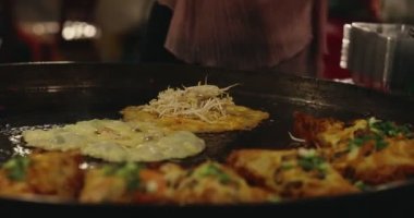 Chef using giant pan fried clams, delicious street food in Thailand.