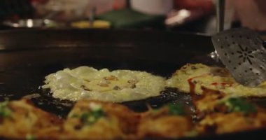 Chef using giant pan fried clams, delicious street food in Thailand.
