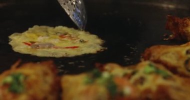 Chef using giant pan fried clams, delicious street food in Thailand.