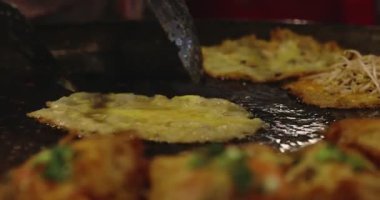 Chef using giant pan fried clams, delicious street food in Thailand.