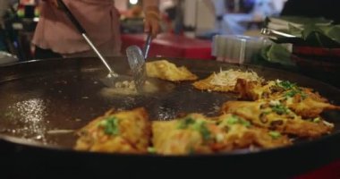 Chef using giant pan fried clams, delicious street food in Thailand.