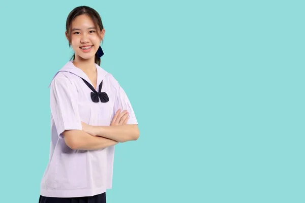 身着校服的亚洲女学生幸福的臂膀交叉在孤立的粉刷背景上 — 图库照片