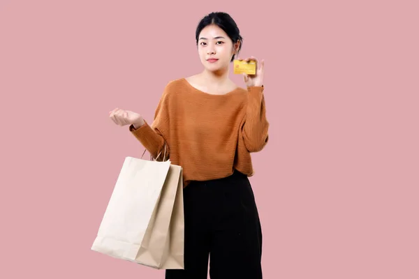 Happy Asian Woman Holding Shopping Bag Showing Credit Card Isolated — Fotografia de Stock