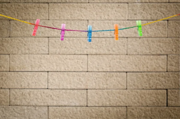 Klädnypor på rainbow rep med moderna vägg bakgrund — Stockfoto