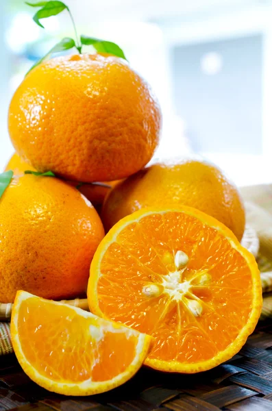 Tangerines με φύλλα σε ένα όμορφο καλάθι, σε Καλαθοπλεκτικής tabl — Φωτογραφία Αρχείου