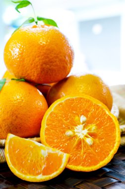 wickerwork tabl üzerinde güzel bir sepet içinde yapraklarla mandalina