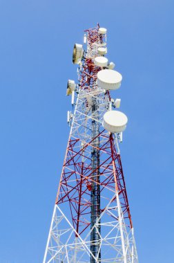 Mavi gökyüzüne karşı antenli iletişim kulesi