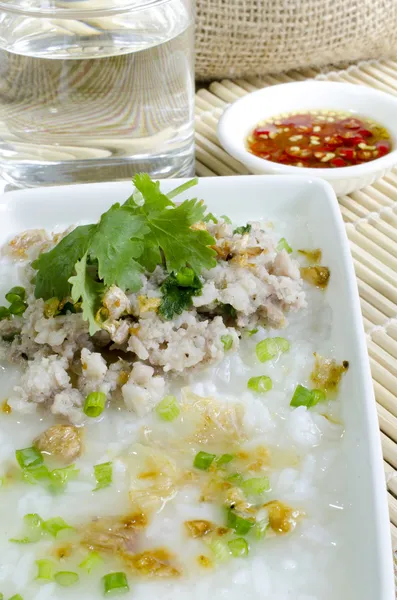 Porco de arroz cozido com copo de água e molho de peixe — Fotografia de Stock