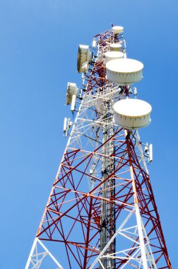 Mavi gökyüzüne karşı antenli iletişim kulesi
