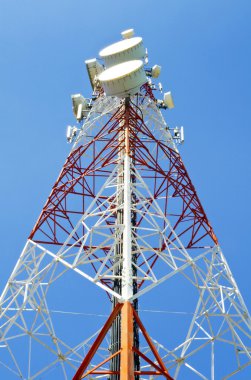 Mavi gökyüzüne karşı antenli iletişim kulesi