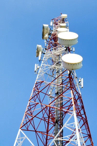 Komunikační věž s anténami proti modré obloze — Stock fotografie