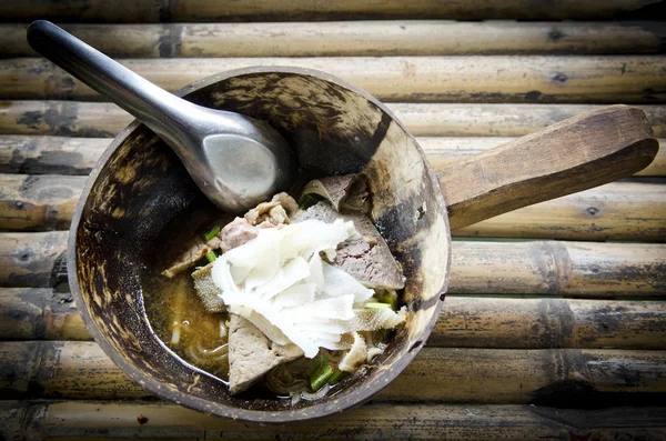 Sopa de macarrão tailandês com carne em fundo de mesa de bambu — Fotografia de Stock