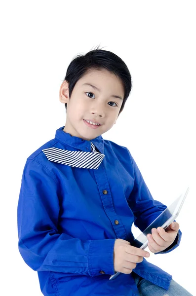 与平板电脑在孤立的坝上小亚洲可爱的男孩微笑 — 图库照片