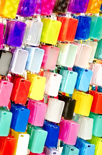 MultiColor plastic mobile phone cases on hangers — Stock Photo, Image