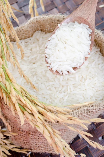 Cucchiaio di legno con riso crudo in sacchetto gunny — Foto Stock