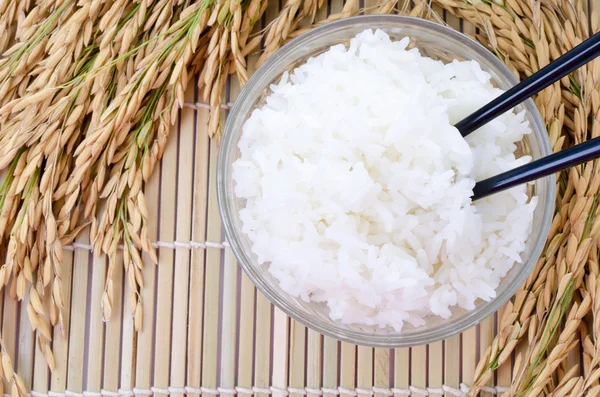 Schüssel mit weißem gedämpften Reis mit Essstäbchen auf Bambusmatte.mit pa — Stockfoto