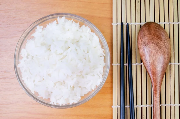 Schüssel mit weißem gedämpften Reis mit Essstäbchen auf Bambusmatte.mit pa — Stockfoto