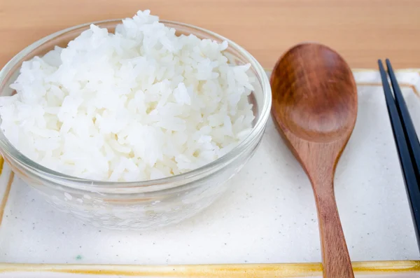 Weißer gedämpfter Reis in Schüssel mit Essstäbchen und Holzlöffel . — Stockfoto