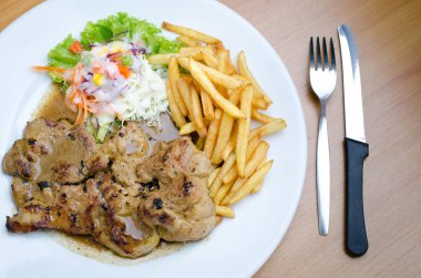 Izgara biftek, patates kızartması ve sebze.