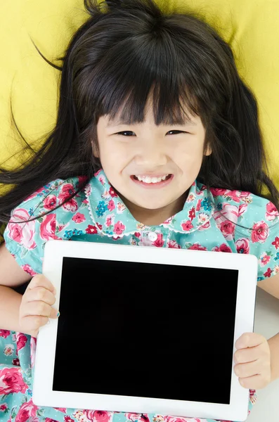 Pequeña chica asiática sonríe con tableta ordenador — Foto de Stock