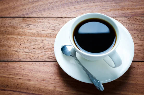 Cup of coffee on an old wooden table — Stock Photo, Image