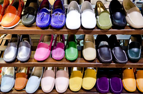 Разнообразие разноцветной кожаной обуви в магазине — стоковое фото