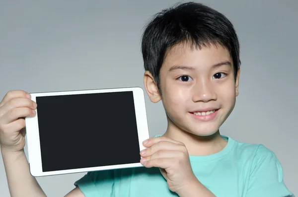 Pouco asiático menino sorri com tablet computador — Fotografia de Stock