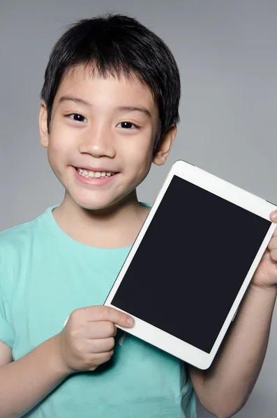 Little asian boy smiles with tablet computer — Stockfoto