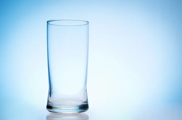 Hohes leeres Glas Wasser auf blauem Grund — Stockfoto