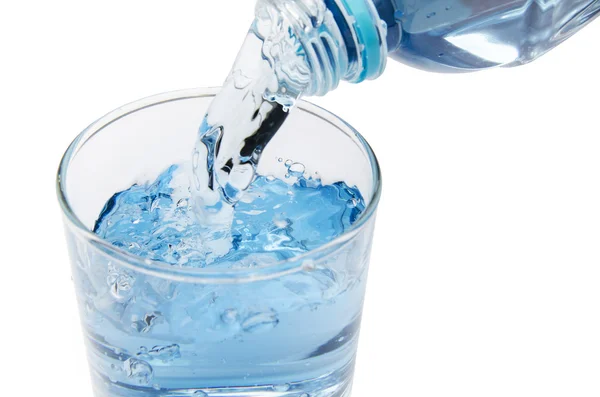 Reines Wasser wird in ein Glas Wasser aus der Flasche entleert — Stockfoto