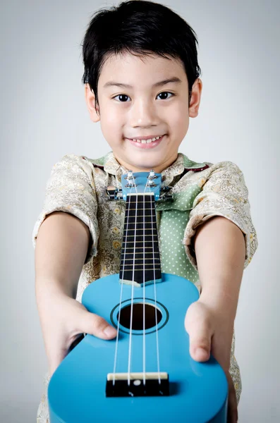Asian child  with his ukulele — Stock Photo, Image