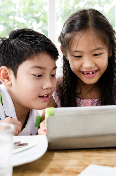Liten asiatisk flicka och pojke med tablet PC — Stockfoto