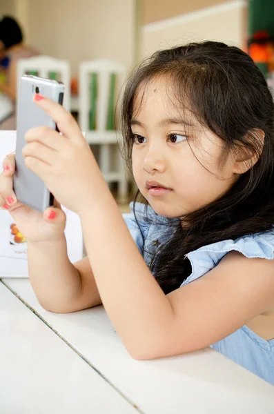 Šťastné asijské dítě dotýkat s Kobaltová modř telefon — Stock fotografie