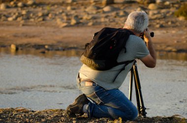 Adam kuşların resmini çekiyor. Juncalillo del Sur Bilimsel İlgi Alanı. San Bartolome de Tirajana. Büyük Kanarya. Kanarya Adaları. İspanya.