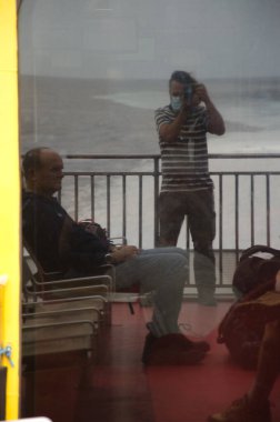 Fotoğrafçı ve oturan adam bardağa yansıdı..