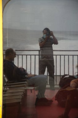 Fotoğrafçı ve oturan adam bardağa yansıdı..