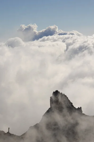 Acantilado, mar de nubes y columna de humo de una erupción volcánica. — Foto de Stock