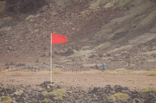 Dos hombres caminando cerca de una bandera roja sin baño. —  Fotos de Stock
