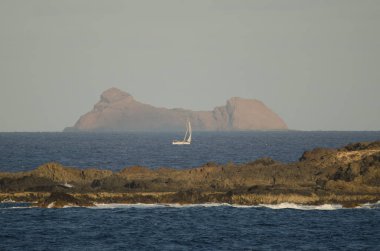Sailboat sailing between La Graciosa and Roque del Este. clipart