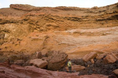 Büyük kayaların arasındaki uçurumun altında bir kadın.