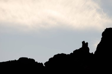 Kayalık profil ve bulutlar.