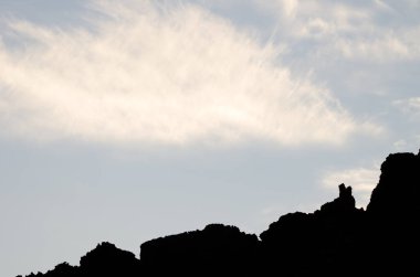 Kayalık profil ve bulutlar.